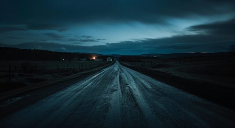 Empty rural road stretching into darkness at dusk, symbolizing the isolation in Hallow Road